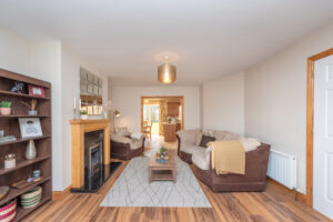 living-room photo with sofa,wooden floor,fireplace,bookcase,coffee table, rug